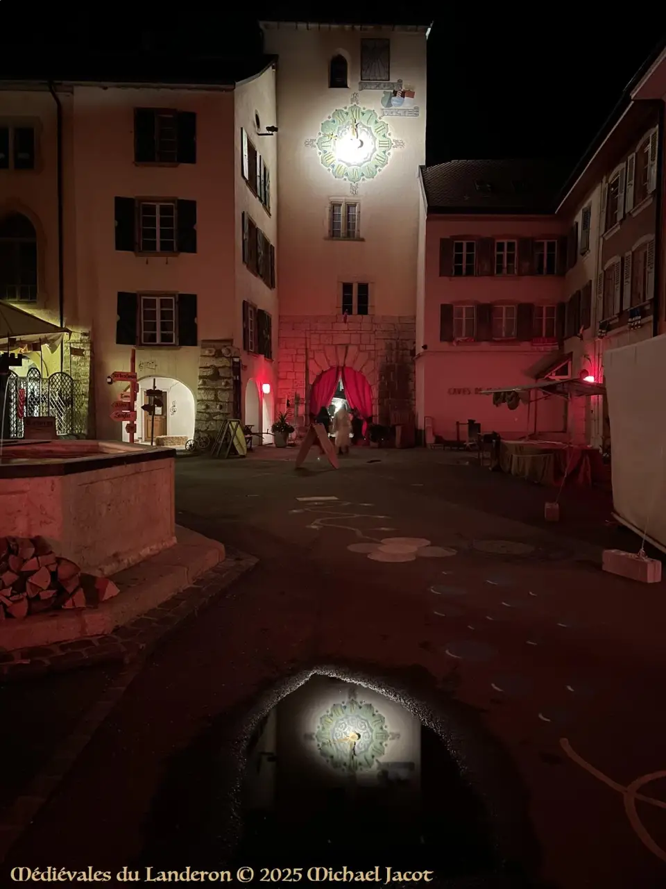 Tour du château de nuit avec son reflet dans une flaque d'eau
