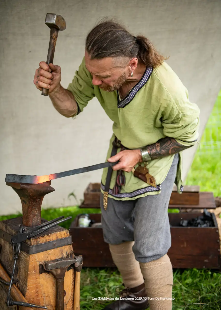 Forgeron martelant du fer